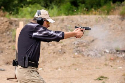 man shooting a pistol at a gun range